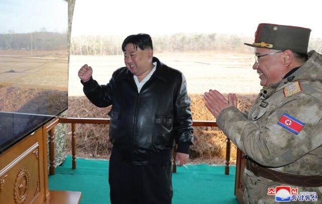 North Korean leader Kim Jong Un (L) attending an ultra-large rocket firing drills, release