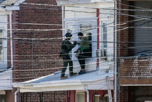 Police evacuate residents from a home in Trenton, New Jersey, where a suspect was believed
