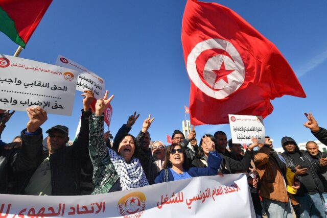 Trade unionists shout slogans as they take to the streets of Tunis to protest against prop