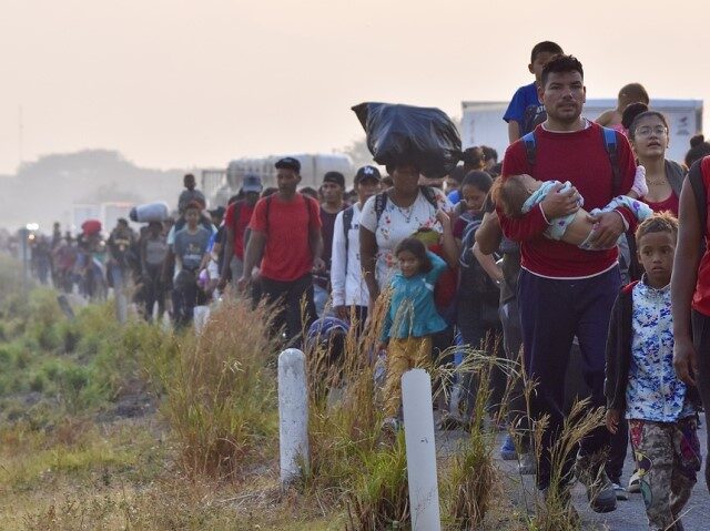 Migrants walk along the highway through Arriaga, Chiapas state in southern Mexico, early M