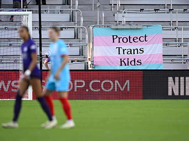 A transgender pride flag with a "Protect Trans Kids" message is displayed beside