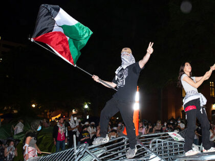 George Washington University students, protesting the Israel-Hamas war, stand on top of po