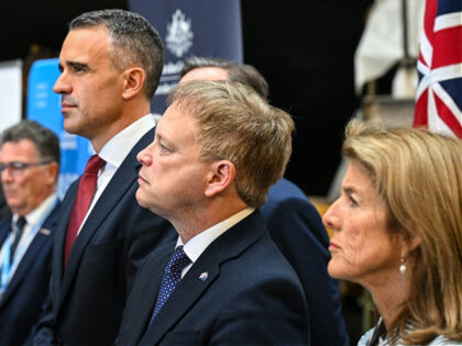 Britain's Secretary of State for Defence Grant Shapps (C) stands next to South Australian