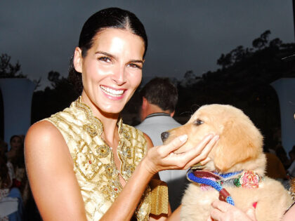 MALIBU, CA - JULY 21: Actress Angie Harmon (L) strokes a young dog that dog breeder Marjor