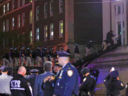 NYPD officers in riot gear break into a building at Columbia University, where pro-Palesti