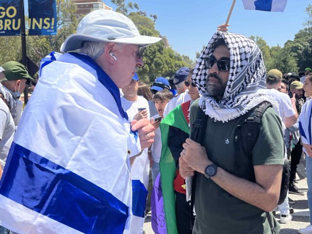 A pro-Israel protester and a pro-Palestinian protester debate each other on the sidelines