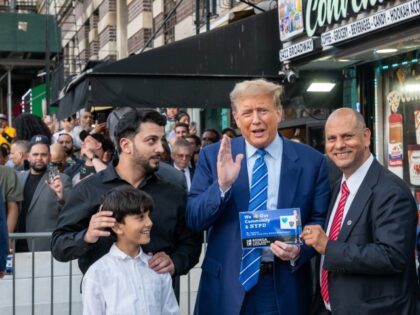 Former president Donald Trump stands with local politicians and bodega workers as he visit