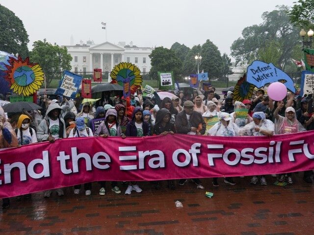 Climate activists hold a rally to protest the use of fossil fuels on Earth Day in the rain