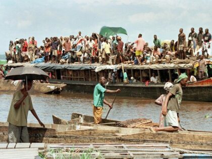 A canoe passes an overloaded ferry boat 13 December on the Congo River at Kinshasa, where
