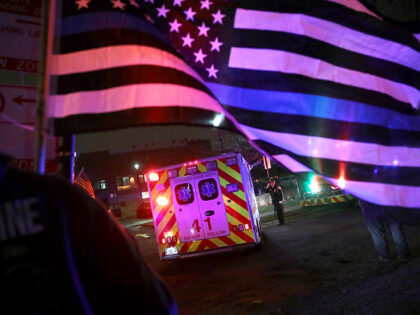 Police and firefighters follow the ambulance carrying the remains of Chicago Police office