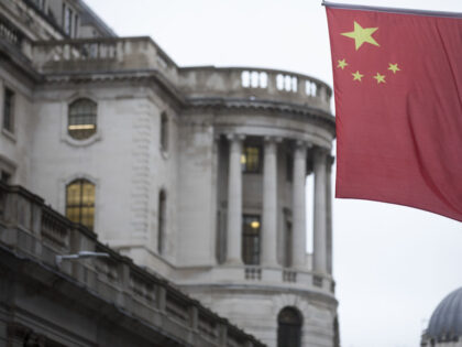 A Chinese national flag flies from the side of the Bank of China Ltd. building in view of