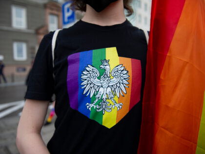 A demonstrator wears a t-shirt with Polands' coat of arms on a rainbow background during a