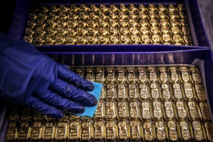 TOPSHOT - A worker polishes gold bullion bars at the ABC Refinery in Sydney on August 5, 2