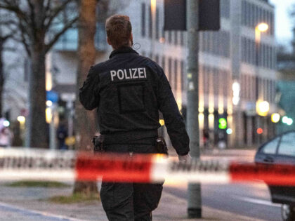 25 March 2023, Lower Saxony, Göttingen: A policeman walks along behind a barrier tape. In