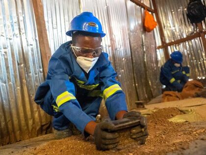 A worker crushes ore by hand in the artisanal copper-cobalt mine of Kamilombe, near the ci