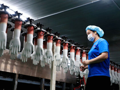 An employee works on the production line of PVC gloves at a factory of Jiangsu Dingjie Med