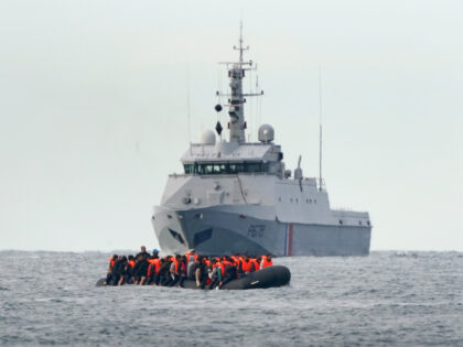 A group of people thought to be migrants are escorted by a French patrol vessel as they cr