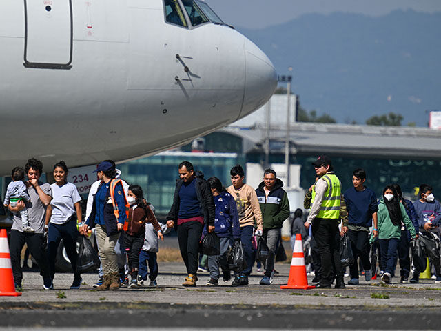 Guatemalan migrants deported from the United States walk on the tarmac after landing at th