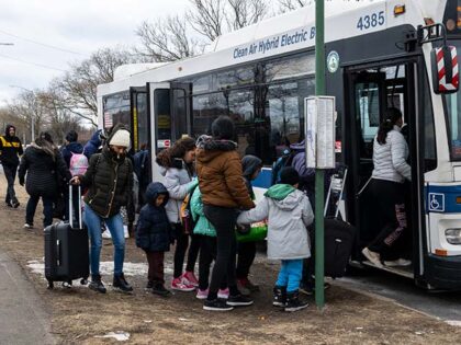 Recently arrived migrants get on a bus outside Floyd Bennett Field shelter on February 21,