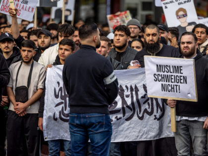 27 April 2024, Hamburg: Participants in an Islamist demonstration hold up a poster with th