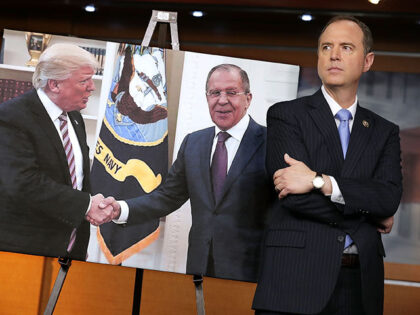 House Intelligence Committee ranking member Rep. Adam Schiff (D-CA) stands next to a photo