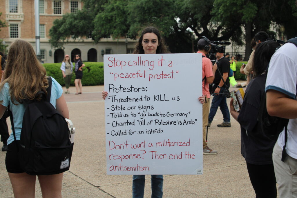 Jewish student carries sign explaining what happened on first day of pro-Palestine protest at the University of Texas. (Randy Clark/Breitbart Texas)