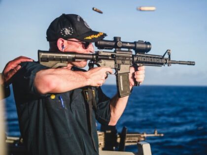 Navy commander shooting rifle with scope backwards