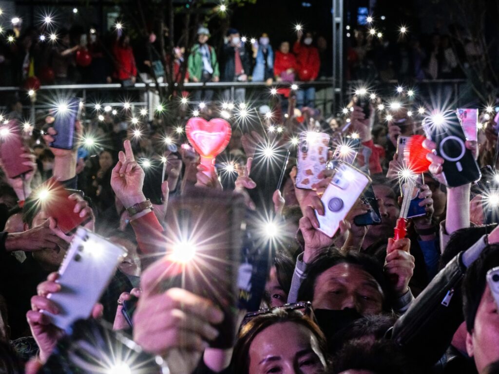 Supporters raise their phone torches during a campaign rally for South Korea's ruling People Power Party (PPP), on the eve of the parliamentary elections in Seoul on April 9, 2024. (Photo by Anthony WALLACE / AFP)