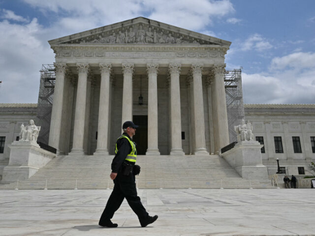 A police officer walks on the plaza of the US Supreme Court as the court hears arguments o