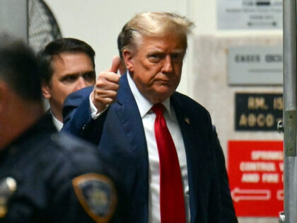 Former President Donald Trump gives a thumbs up as he walks to the courtroom after a break