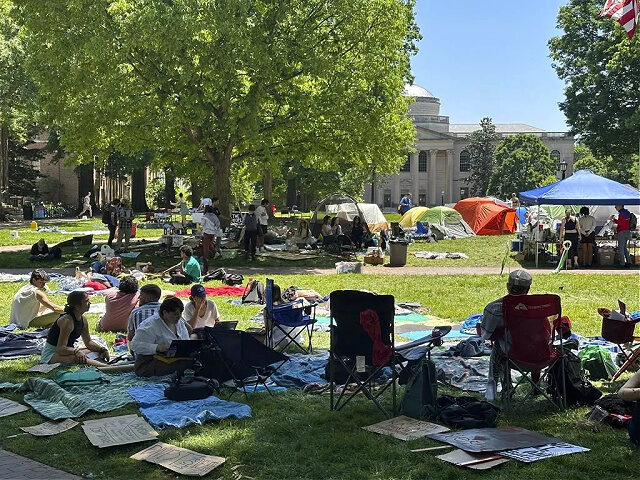 Students work on assignments and listen to organizers as they sit inside the encampment pr