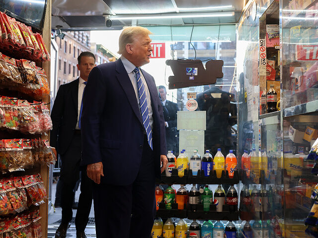 Former preident Donald Trump talks with bodega owner Maad Ahmed during a visit to his stor
