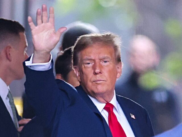 Former US President Donald Trump waves as he departs Trump Tower for Manhattan Criminal Co