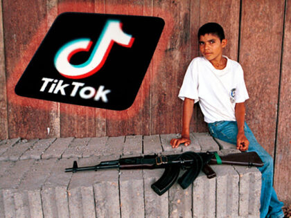 A boy sits near an AK-47 assault rifle at a FARC check point February 26, 2001 in Cristale