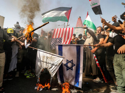 Iraqis set Israeli flags on fire during a solidarity march with the Palestinians, in the c