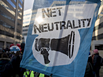 A demonstrator opposed to the roll back of net neutrality rules holds a sign outside the F