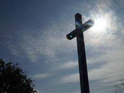 Christian wooden cross on a background with the sun