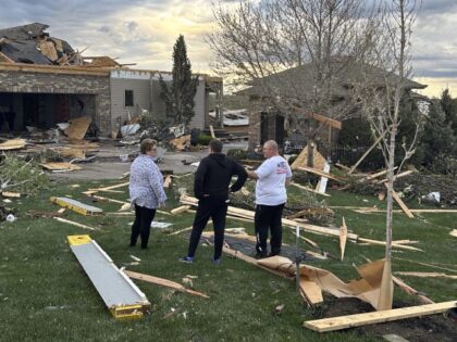 Homeowners assess damage after a tornado caused extensive damage in their neighborhood nor