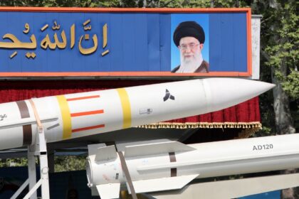 An Iranian military truck carries a Sayad 4-B missile past a portrait of supreme leader Ay