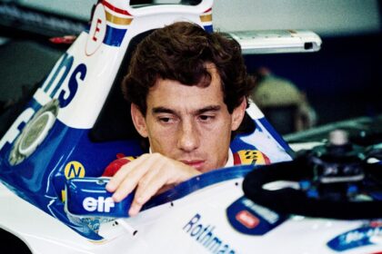 Ayrton Senna adjusts his mirror in the pits at Imola ahead of his last race