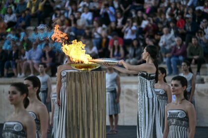 Greek actor Mary Mina playing the role of the High Priestess lights the Olympic torch duri