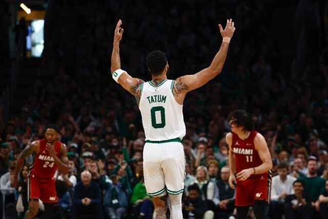 Jayson Tatum of the Boston Celtics raises his hands after making a three point basket agai