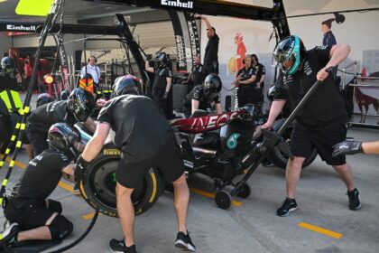 Mechanics practice pit stops with the car of Mercedes' British driver Lewis Hamilton ahead