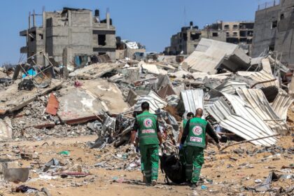 Palestinian paramedics carry away bodies of dead people uncovered in the vicinity of Al-Sh