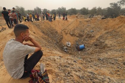 Palestinians examine a bomb crater Israeli bombardment in Rafah, the southern Gaza Strip