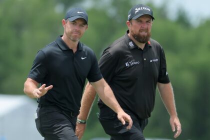 Rory McIlroy of Northern Ireland and Shane Lowry of Ireland wave to fans during the second