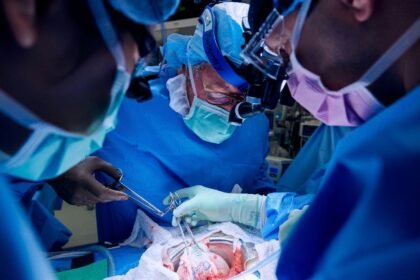 Surgeon Robert Montgomery assists in lowering the gene-edited pig kidney into patient Lisa