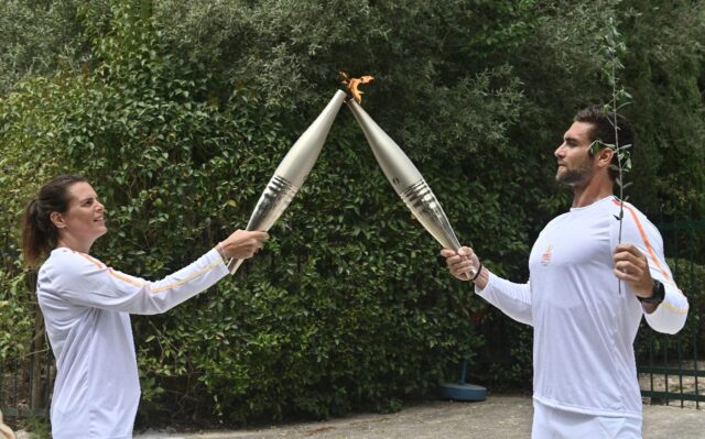 The first torchbearer, Olympic rowing gold medallist Stefanos Ntouskos handed over to the