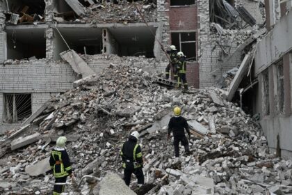 Ukrainian rescue workers clear rubble from a destroyed building in Chernigiv