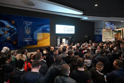 Ukrainians gathered at a closed Ukrainian passport service point at a shopping center in W